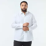 Camisa de manga larga con corte regular fit, color blanco con estampado de pequeños puntos negros. Presenta cuello clásico y cierre frontal con botones.