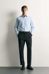 Camisa negra de corte regular fit, cuello italiano, manga larga con puño abotonado y cierre frontal con botones.