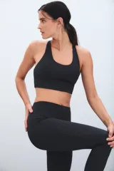 Calza deportiva de tiro alto color marrón, con diseño de perforaciones láser en la parte inferior de las piernas.
