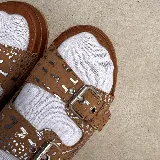 Sandalias de cuero color marrón con doble tira con hebilla ajustable, plantilla de cuero y suela de goma.