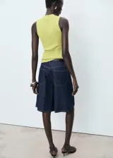 Top de punto de canalé color amarillo lima, sin mangas, con cuello alto y diseño entallado.