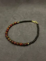 Collar artesanal corto con cuentas de piedras naturales facetadas en tonos tierra, marrones y verdes.