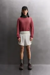 Short deportivo de trail running confeccionado en tejido técnico elástico con textura. Presenta una cintura elástica ancha con compartimentos integrados, bolsillo trasero con cierre y aberturas laterales en el bajo.