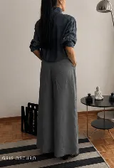 Pantalón de tiro alto con corte wide leg y diseño de pinzas frontales. Confeccionado en lino natural, presenta una silueta amplia y fluida con bolsillos laterales.