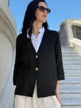 Blazer blanco de lino con solapas y bolsillos frontales.