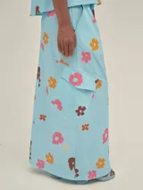 Falda larga celeste con estampado floral, estilo cargo, con cintura ajustable, tajo frontal y bolsillos laterales.