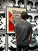 Remera gris con efecto gastado, corte oversize, mangas cortas y estampado en la espalda con el texto "SUPPLY GOODS DESIGNED IN PUNTA DEL ESTE".