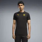 Remera Puma de entrenamiento del Club Atlético Peñarol, modelo CAP Tee, color negro con detalles en amarillo, incluyendo el logo de la marca y el escudo del club.
