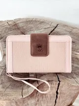 Billetera grande color rosa con cierre de cremallera, detalle de pespuntes y aplique marrón con logo de búho. Incluye correa de muñeca.
