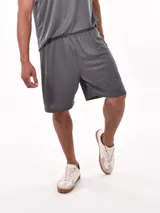 Short deportivo de corte holgado en color gris, confeccionado en tejido técnico con textura microperforada, cuenta con cintura elástica para mayor comodidad.