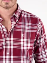 Camisa de hombre de manga larga, corte regular fit, cuello button down y cierre con botones. Diseño a cuadros tartán en tonos rojo y blanco.