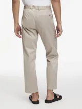 Pantalón de vestir color beige claro, de corte recto y ajuste regular, con cierre de botón y cremallera.