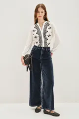 Pantalón de jean estilo corderoy negro, de corte wide leg y tiro alto, con bolsillos delanteros parcheados.