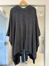 Ruana negra con hilo brillante lurex, de diseño amplio y abierto al frente.