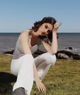 Pantalón oxford de tiro alto, color blanco con finas rayas verticales grises y cierre lateral.