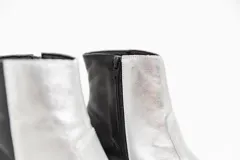 Botas cortas de cuero negro, con punta cuadrada y cierre lateral.