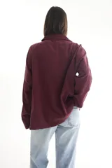 Camisa negra de pana, corte oversize, con cuello camisero, cierre frontal con botones, dos bolsillos con solapa en el pecho y mangas largas con puños abotonados.