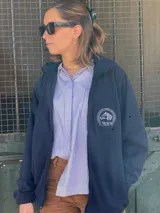 Campera polar azul marino con cierre frontal y cuello alto. Cuenta con el logo bordado de Criollos en el pecho.