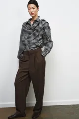 Pantalón de tiro medio confeccionado en mezcla con lana. Presenta diseño de corte recto con detalle de pinzas en el delantero, trabillas en la cintura y bolsillos laterales. Cierre frontal con cremallera, botón y ganchos metálicos.