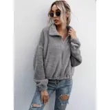 Campera corta de textura peluda tipo polar, color gris, con cierre frontal, cuello alto y elástico ajustable en la cintura.