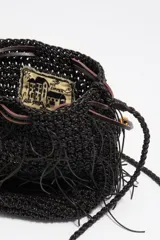 Bolso mini tipo bombonera de color marrón oscuro, confeccionado con tejido trenzado y detalles de flecos colgantes. Cuenta con cierre de cordón ajustable y correa cruzada trenzada.