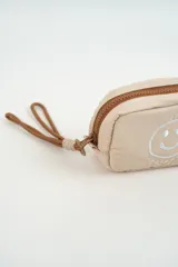 Neceser acolchado color beige con diseño de carita feliz bordada en el frente y cierre superior con tirador de cordón.