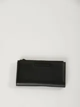 Billetera rectangular de diseño minimalista en color negro, con cierre superior y placa metálica decorativa con el logo de la marca en el frente.