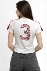 Remera de algodón color azul marino, con cuello redondo, mangas cortas y estampado gráfico en el pecho. Presenta detalles de líneas blancas en los hombros.