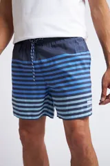 Short de baño con cintura elástica y cordón ajustable, confeccionado en tela ligera de secado rápido. Presenta un estampado botánico integral en tonos amarillos, blancos y azules, con dos bolsillos delanteros y uno posterior.