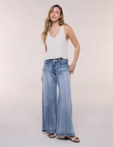 Jean wide leg de tiro alto en denim azul claro, con calce ajustado en la cadera, costuras verticales frontales y bolsillos estilo carpintero.
