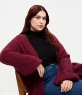 Cardigan abierto de punto pesado con textura peludita, manga larga y diseño alargado. Prenda versátil de corte holgado.