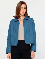 Chaqueta de algodón azul con diseño acolchado bordado, cuello camisero, cierre frontal con botones metálicos y bolsillos frontales.