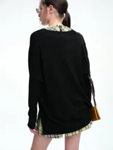 Sweater de punto color gris, con escote en V profundo, hombros caídos y diseño holgado de corte relajado.