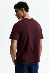 Remera de algodón liviano color bordó, con cuello redondo ribeteado y mangas cortas, de corte estándar.