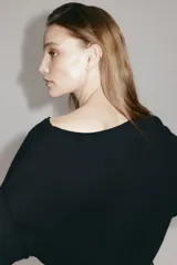 Top de punto fino transparente color negro, de manga larga con hombros caídos, escote bote amplio y ribete enrollado, con remate acanalado ancho en puños y bajo.