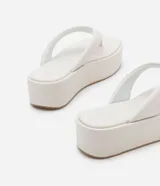 Ojotas negras con plataforma plana, tiras anchas y puntera redonda.