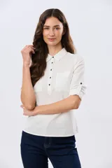 Camisa de lino lisa color celeste, de manga larga con puños abotonados y trabilla para arremangar. Cuenta con cuello clásico, cierre frontal con botones y bolsillos plaqué en el pecho.