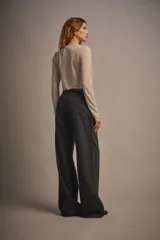 Body negro de microfibra translúcida esmerilada, ajustado al cuerpo, con mangas largas, cuello media polera y frunce central en el delantero. Tiene acceso por entrepierna con broches metálicos.