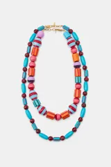 Pack de dos collares multicapa compuestos por cuentas de resina de diferentes formas y tamaños, en tonos turquesa, naranja, rojo, rosa y lila, con detalles rayados. Cierre de mosquetón metálico.