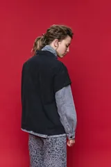 Chaleco de jean oversized color negro, con cuello camisero y cierre frontal con botones metálicos. Presenta un diseño estructurado con costuras reforzadas.