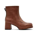 Bota de vestir de caña media en color marrón, con taco cuadrado y plataforma delantera. Presenta un diseño minimalista con costuras visibles y detalle de borde en color negro.