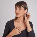 Pulsera de plata 925 con diseño de dos aros entrelazados decorados con circonias brillantes. Cuenta con cadena fina ajustable y cierre de seguridad.