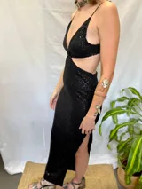 Vestido largo de fiesta negro con lentejuelas, escote en V, breteles finos, corte en la cintura y tajo en la pierna.