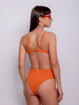 Parte inferior de bikini tiro alto color naranja, con textura de flores.