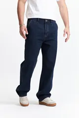 Jean azul oscuro de corte carpenter, relajado y funcional, con tiro medio y pasacinto.