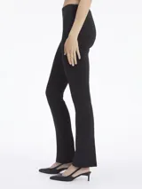 Pantalón negro de punto técnico, corte slim, pierna acampanada con aberturas traseras, talle medio, cierre de cremallera oculto y detalles de costuras verticales.