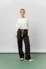 Pantalón de corte relajado y pierna recta, confeccionado en tejido tipo corderoy liviano. Presenta cintura elastizada con cordón ajustable y diseño de silueta amplia.