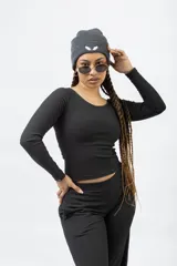 Remera de manga larga color blanco hueso, con cuello redondo y tejido acanalado.