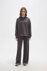 Canguro con capucha de calce holgado, color bordó, con detalle de aplique de strass en el pecho.