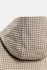 Cazadora con capucha ajustable, manga larga con puños elásticos, bolsillos delanteros y bajo ajustable con cordones. Cierre frontal con cremallera y diseño estampado a cuadros.